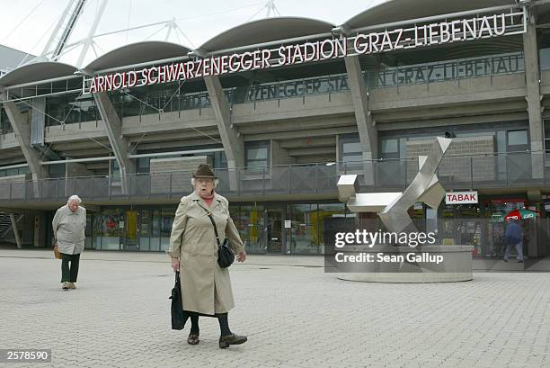 Two elderly people walk past the soccer stadium named after Arnold Schwarzenegger October 10, 2003 in Graz, Austria. Schwarzenegger was born in...