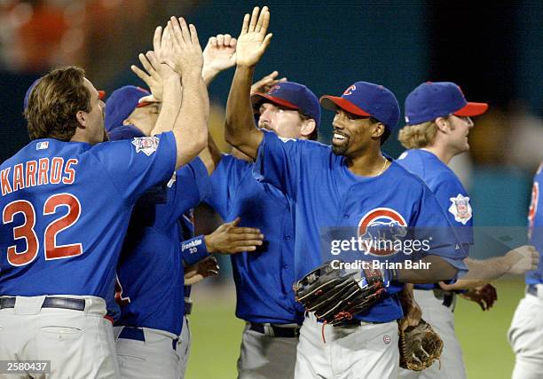 Doug Glanville of the Chicago Cubs celebrates with teammates after defeating the Florida Marlins in game three of the National League Championship...