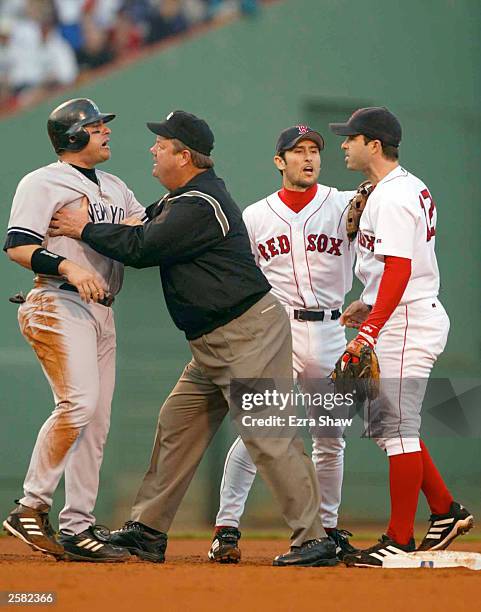 Karim Garcia of the New York Yankees is held back by the second base umpire after sliding into Todd Walker of the Boston Red Sox during Game 3 of the...