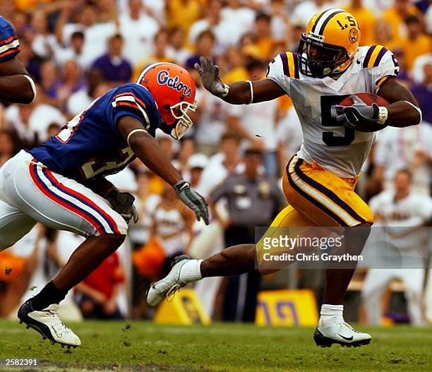 Andre Caldewell of the Louisiana State University Tigers avoids a tackle from Daryl Dixon of the University of Florida Gators on October 11, 2003 at...
