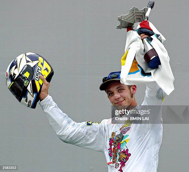 Valentino Rossi of Italy celebrates with his trophy after winning the Malaysian Motorcycle Grand Prix in Sepang 12 October 2003. Rossi won the race...
