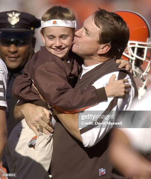 Butch Davis head coach of the Cleveland Browns lifts his son Drew Davis and gives him a hug and kiss as they meet on the field after Cleveland''s win...