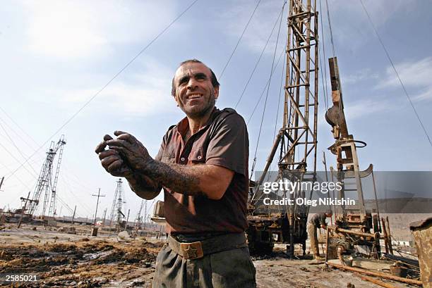 Oil workers service a well in the oilfields October 12, 2003 near Baku, Azerbaijan. The country is preparing to elect its first new prime minister...