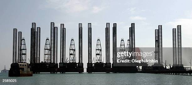 Oil platforms stand near the coast while they are being prepared to be transported out to the oilfields in the Caspian Sea, October 12, 2003 near...