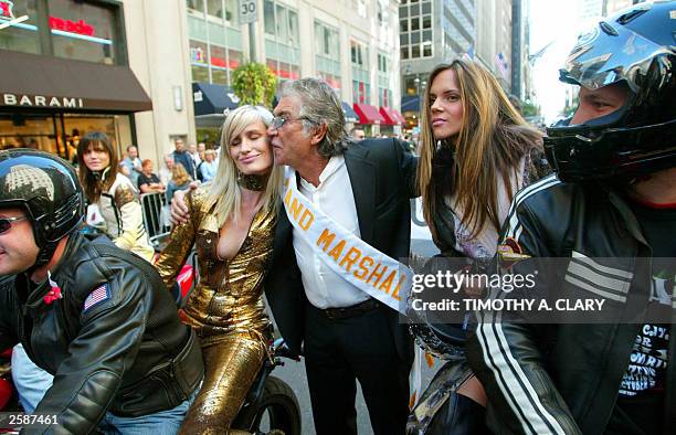 Parade Grand Marshall and Italian Fashion designer Roberto Cavelli kisses models wearing his creations as they ride down 5th Avenue, 13 October 2003,...