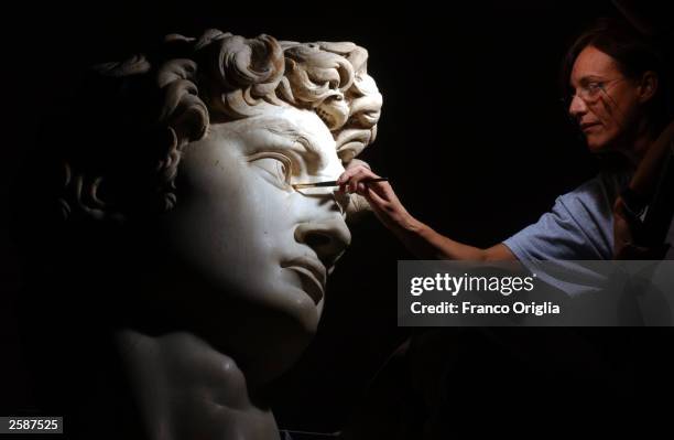 Restorer Cinzia Parnigoni cleans Michelangelo''s masterpiece "David" during restoration work at the Galleria dell''Accademia October 6, 2003 in...