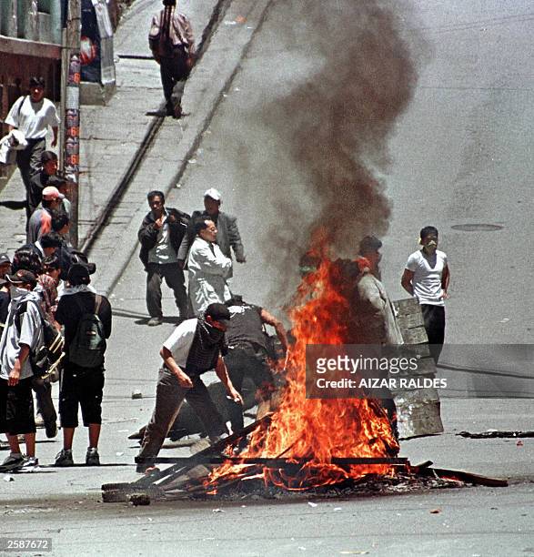 Demonstrators set tyres on fire 13 October 2003 in downtown La Paz in protest against the plans to export Bolivian gas through Chile. Two more people...