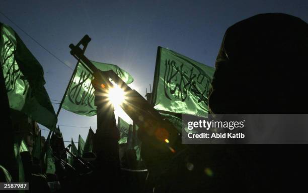 Masked Palestinian Hamas militants march during a protest demonstration at the Rafah refugee camp October 13, 2003 in the Southern Gaza Strip....