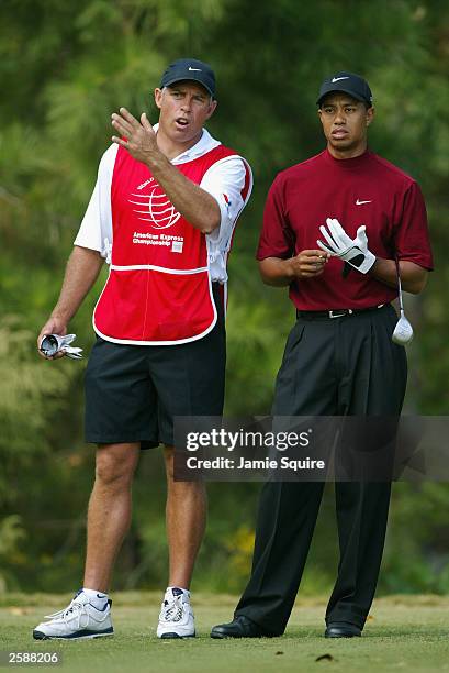 Tiger Woods receives direction from caddie Steve Williams prior to hitting his first shot on the 5th hole during the final round of the World Golf...