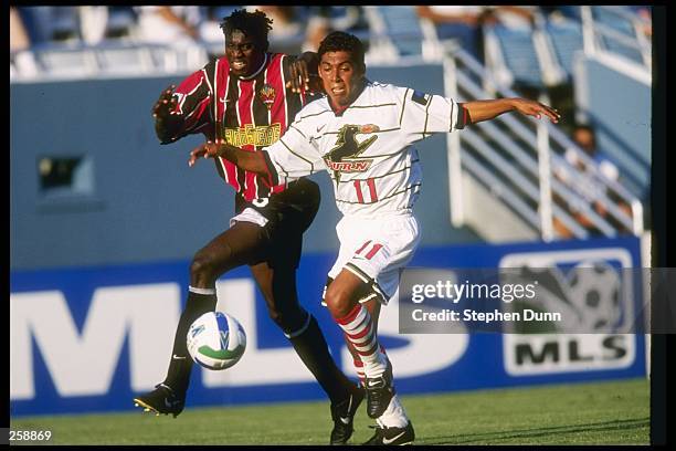 Damian Alvarez of the Dallas Burn is grabbed from behind by Ezra Hendrickson of the MetroStars during the Burn 3-1 MLS win over the New York/New...