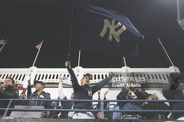 Fans of the New York Yankees celebrate during game one of the World Series against the Atlanta Braves at Yankee Stadium in Bronx, New York. The...