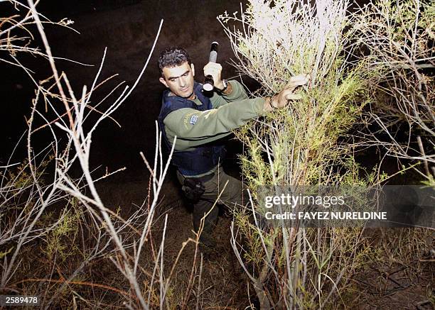 Greek border guard saerches the area near the Evros river during a patrol on the Greek side of the river which separates Greece and Turkey at Kipi...