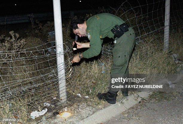 Greek borderguard checks a barbed wire fence during a patrol at the Greek side of the Evros river which separates Greece and Turkey at Kipi village,...