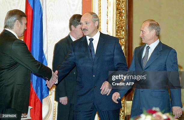 Belarus President Alexander Lukashenko , flanked by Russian President Vladimir Putin , shakes hands with Russian Premier Mikhail Kasyanov ahead of a...