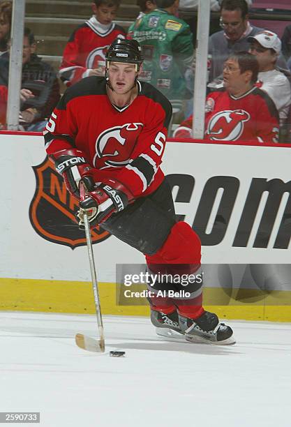 Defenseman Colin White of the New Jersey Devils plays the puck against the New York Rangers during the preseason NHL game on October 3, 2003 at...