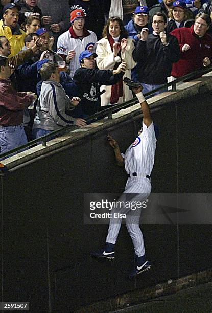 Fans interfere with outfielder Moises Alou of the Chicago Cubs on a ball hit by Luis Castillo of the Florida Marlins in the eighth inning during Game...