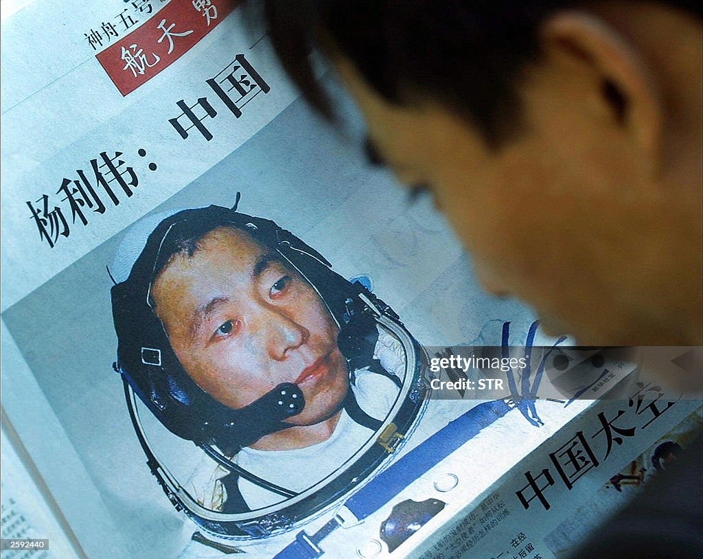 A man reads a newspaper profiling Chines