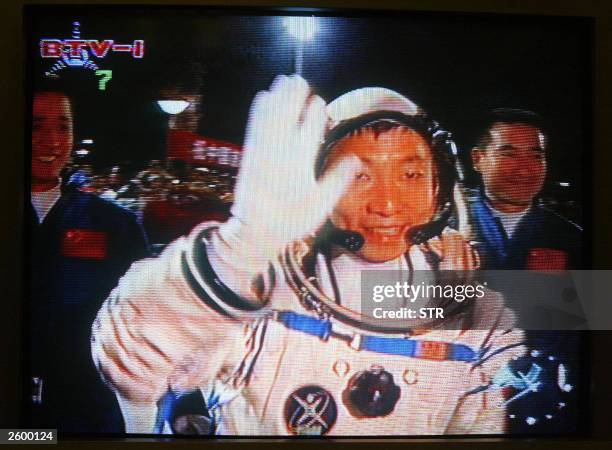 Grab shows Chinese astronaut Yang Liwei waving as he heads to board the Shenzhou V spacecraft on a Long March CZ-2F rocket, 15 October 2003, the...