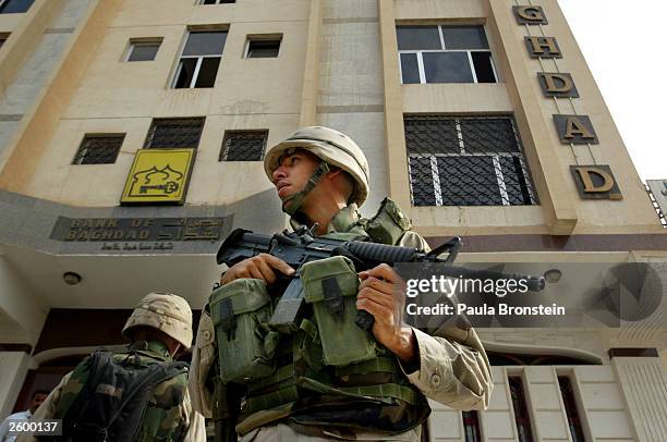 Soldiers stand guard outside the Bank of Baghdad October 15, 2003 in Baghdad, Iraq as the currency is introduced today for the first time. Missing on...