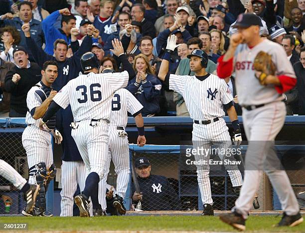 Nick Johnson of the New York Yankees celebrates with teammates Derek Jeter and Jorge Posada after he and Karim Garcia scored on an Alfonso Soriano...