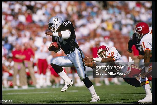 Running back Bo Jackson of the Los Angeles Raiders moves the ball during a game against the Kansas City Chiefs at the Los Angeles Memorial Coliseum...