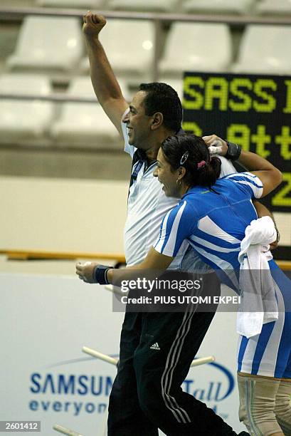 Tunisian Hayet Sassi celebrates with her coach after lifting 122.5 kg clean and jerk 15 October 2003 to win gold and also set a new record at the...