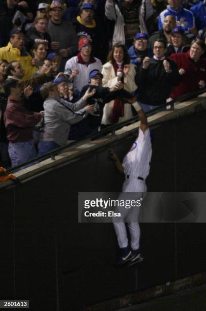Fans interferes with outfielder Moises Alou of the Chicago Cubs on a ball hit by Luis Castillo of the Florida Marlins scoring two runs in the eighth...
