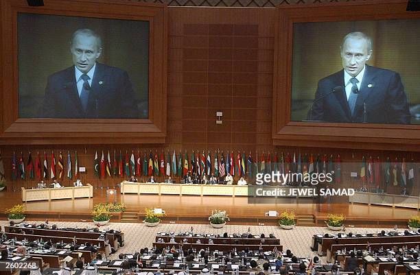 Russian President Vladimir Putin is seen on a huge screen at Putrajaya's convention center as he addresses the opening session of the 10th summit of...