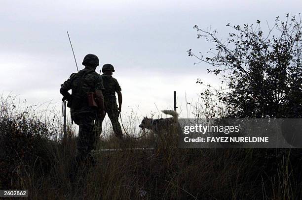 Greek soldiers patrol along the side of a mine field on the Greek side of the Evros river which separates Greece and Turkey 14 October 2003 at Kipi...