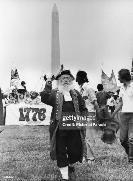 Buster Smith, a member of the People's Bicentennial Commission, rings a bell in costume during an anti-big business protest with the Washington...