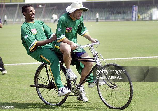 South African batsman Neil McKenzie enjoys a bicycle ride with fast bowler Makhaya Ntini during a practice session at Gaddafi Stadium in Lahore, 16...