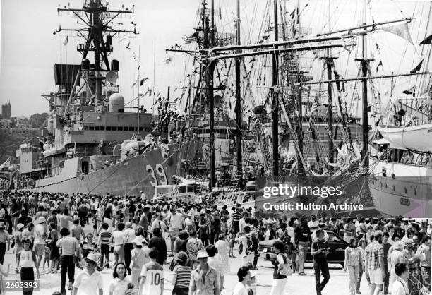 Crowds fill a pier to view tall ships during the American Bicentennial celebrations, July 1976.