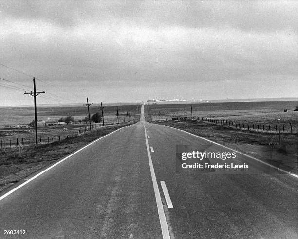 View of a flat rural highway stretching to the horizon in the 'panhandle' portion of Oklahoma, 1940s.