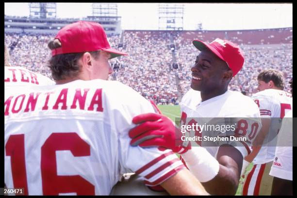 Quarterback Joe Montana and wide receiver Jerry Rice of the San Francisco 49ers talk to each other during a preseason game against the Los Angeles...