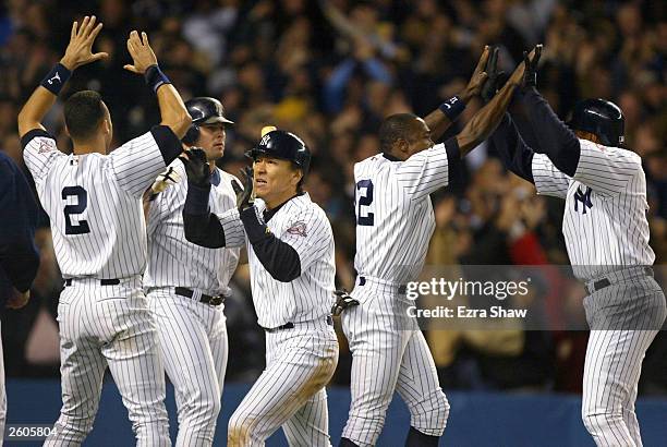 Hideki Matsui of the New York Yankees celebrates with his teammates after scoring the game tying run on a Jorge Posada double in the eighth inning...