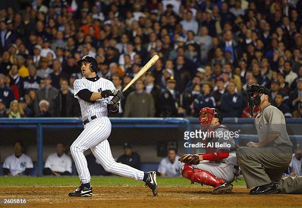 Aaron Boone of the New York Yankees hits the game winning home run in the bottom of the eleventh inning against the Boston Red Sox during game 7 of...