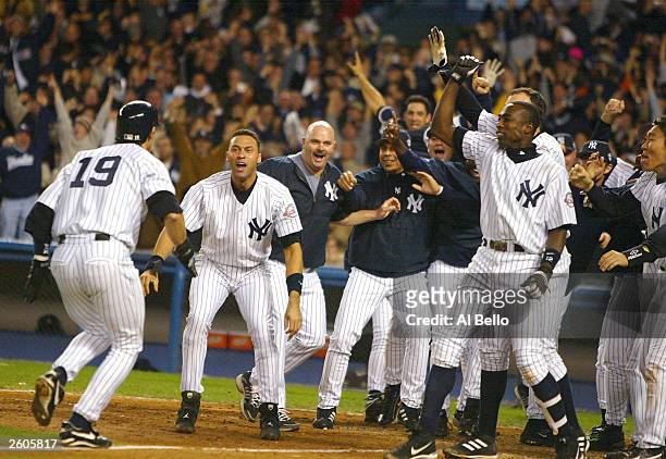 Aaron Boone of the New York Yankees celebrates with his teammates after hitting the game winning home run in the bottom of the eleventh inning...