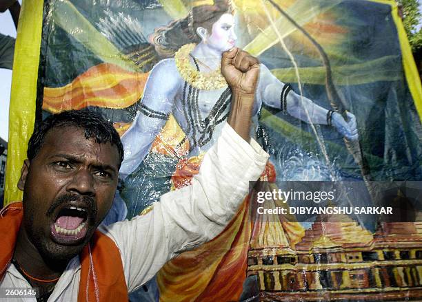 An Indian Hindu devotee shouts slogans in front of a painting of Hindu God Ram in Ayodhya, 17 October 2003. Police fired teargas at a mob of Hindu...