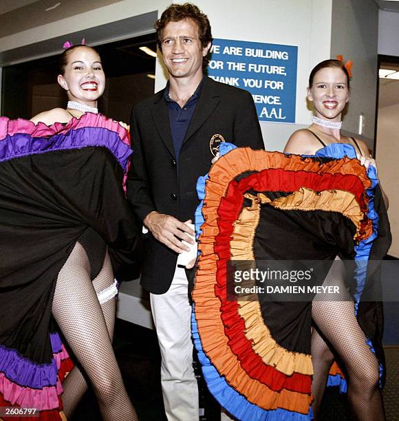 French scrum-half and captain Fabien Galthie is welcomed by frenchcancan dancers at Townsville's airport, 17 October 2003. France play Japan in their...