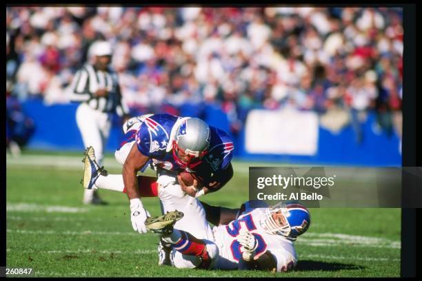 Linebacker Bill Romanowski of the Denver Broncos tackles a New England Patriots player during a game at Foxboro Stadium in Foxboro, Massachusetts....