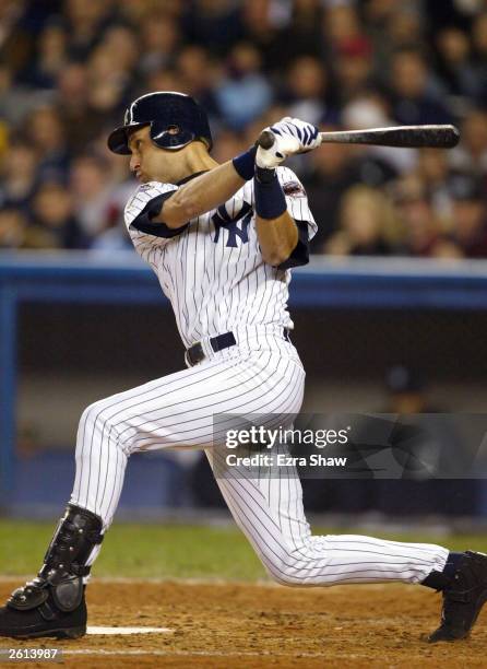 Derek Jeter of the New York Yankees hits an RBI single to score Karim Garcia in the third inning against the Florida Marlins during game 1 of the...