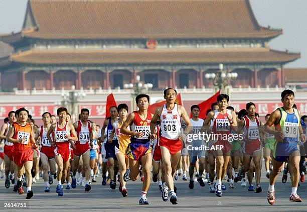 Runners take off from Tiananmen Square in Beijing 19 October 2003, at the start of the Beijing marathon race. China's up and coming women's long...