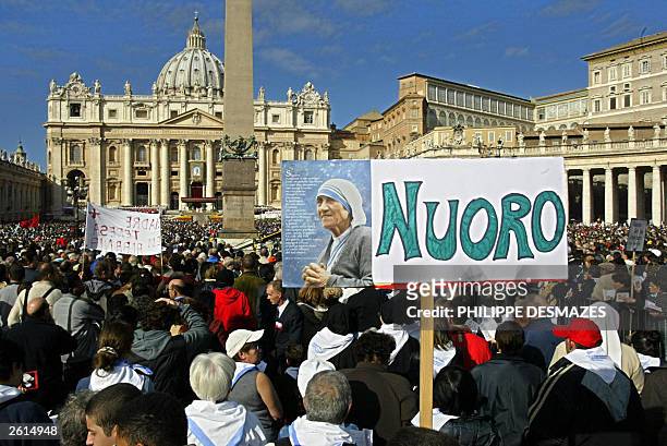 Faithfuls hold posters 19 October 2003 during a mass celebrated by Pope John Paul II for the Beatification of Mother Teresa at St Peter Square in the...