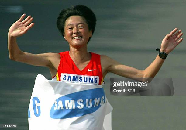 China's Sun Yingjie jubilates as she reaches the finishing line in the women's race of the Beijing marathon, in Beijing 19 October 2003. China's up...