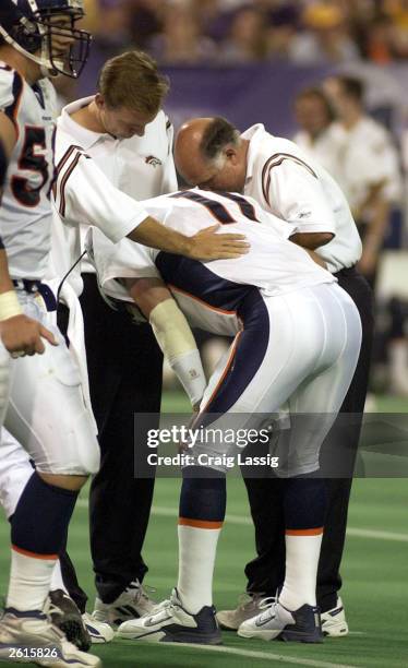 Trainers work on quarterback Steve Beuerlein of the Denver Broncos after he is hurt during their game against the Minnesota Vikings on October 19,...