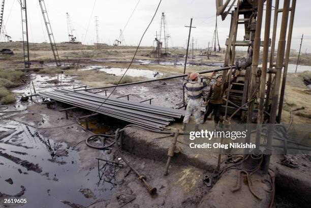 Oil workers service a well in the oil fields on October 19, 2003 near Baku, Azerbaijan. Ilham Aliyev, son of ailing former president Haydar Aliyev,...