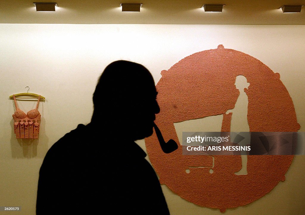 A man walks in front of a knitted image 