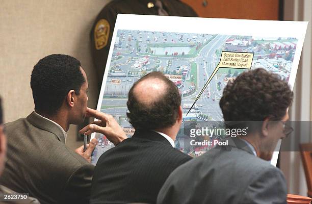 Sniper suspect John Allen Muhammad looks over a prosecution drawing of the murder scene of Dean Meyers, as standby counsel, Jonathan Shapiro and...