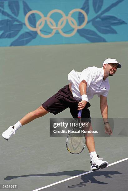 Andre Agassi returns a shot to Leander Paes of India during the XXVI Olympic Games, tennis men's semi-final at the Stone Mountain Tennis Center on...