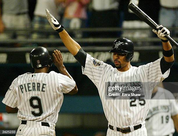 Juan Pierre of the Florida Marlins is congratulated by teammate Derrek Lee after scoring in the first inning against the New York Yankees in Game 3...
